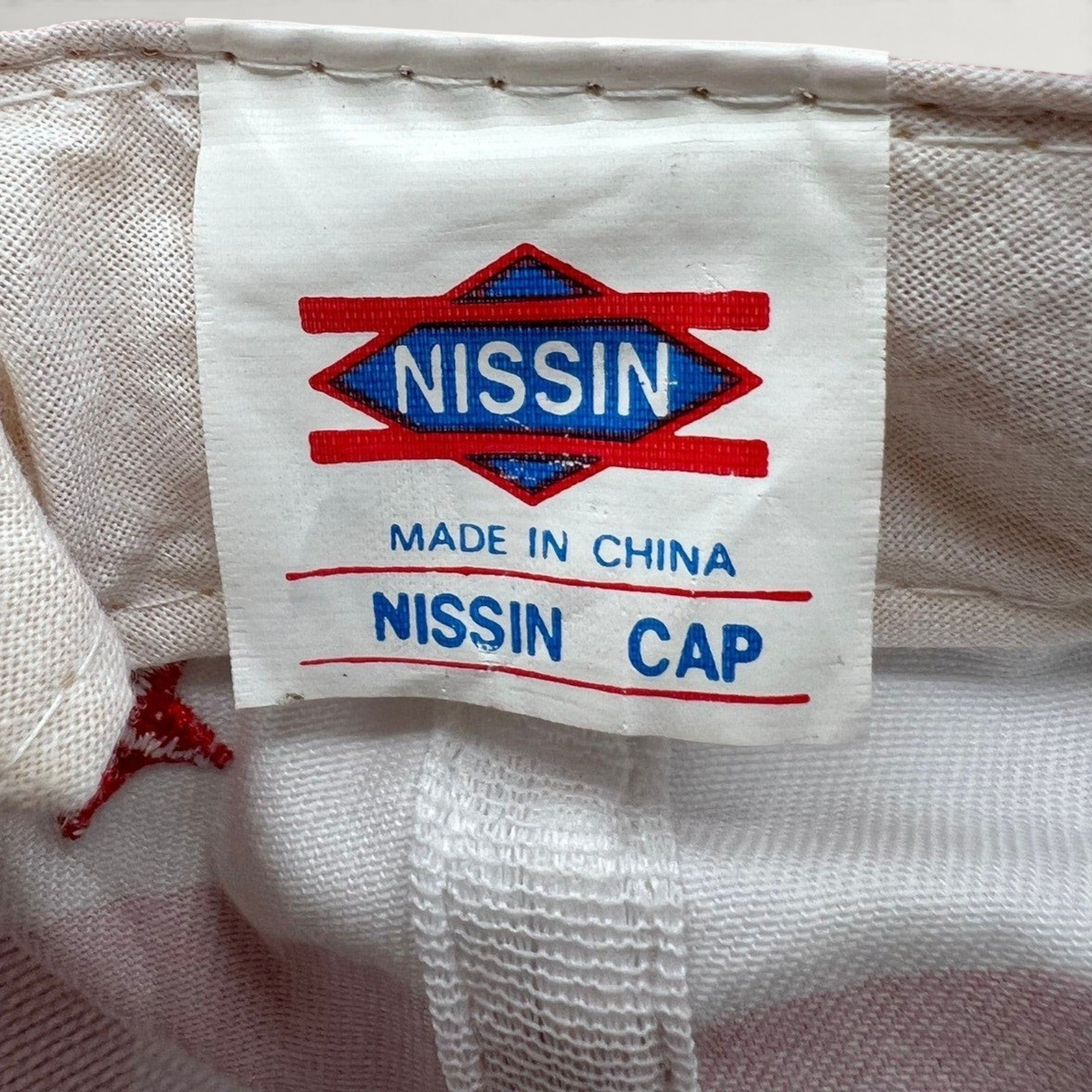 Raree Finds vintage Nissin Cap interior label showing Made in China branding on white cotton fabric