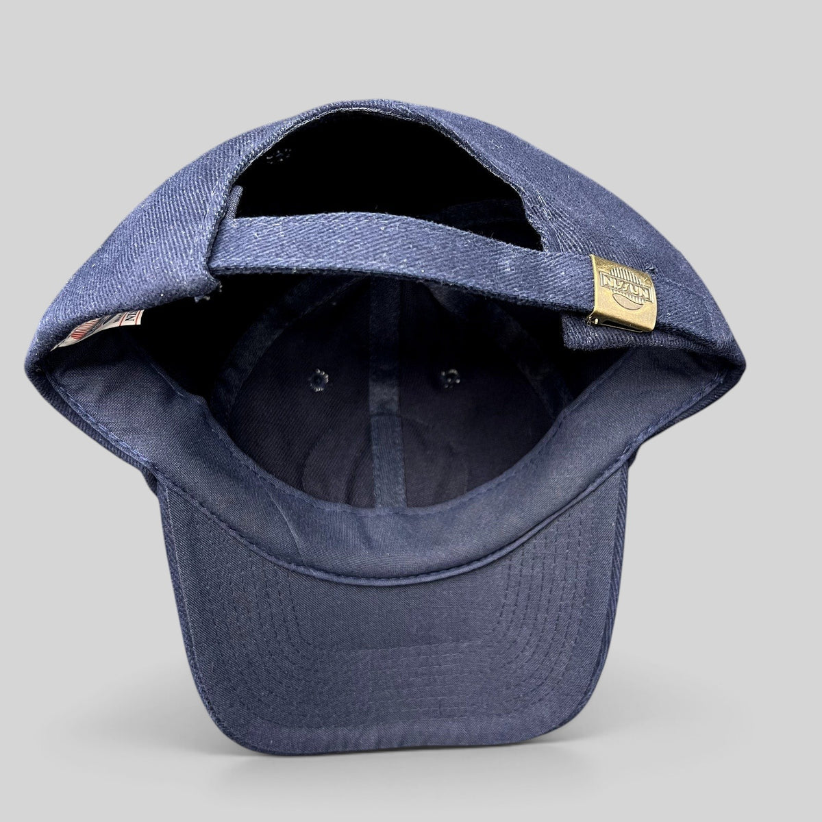 Raree Finds vintage Nissun navy blue cotton strapback hat showing the adjustable metal clasp closure