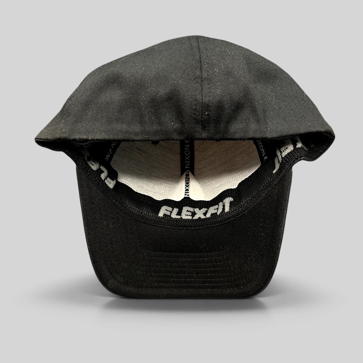 Raree Finds black Nixon Watches Flexfit cap showing the interior stretch-fit construction and branded sweatband