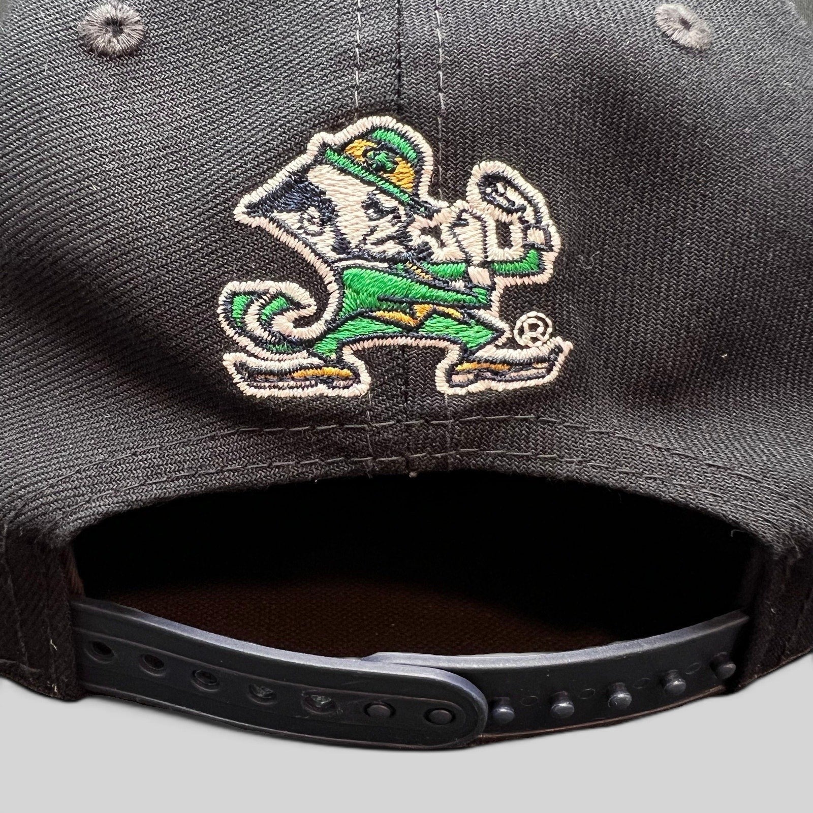 Raree Finds black New Era 9FIFTY snapback hat featuring Notre Dame Leprechaun mascot embroidery on the back