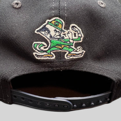 Raree Finds black New Era 9FIFTY snapback hat featuring Notre Dame Leprechaun mascot embroidery on the back