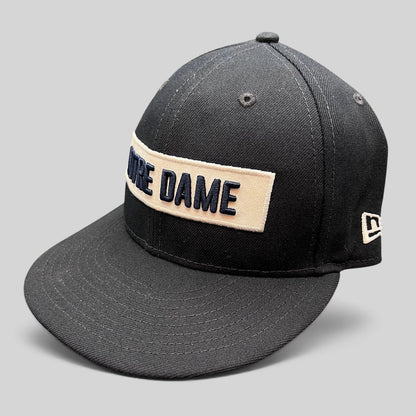 Raree Finds black New Era 9FIFTY snapback hat with cream Notre Dame wordmark patch and flat brim