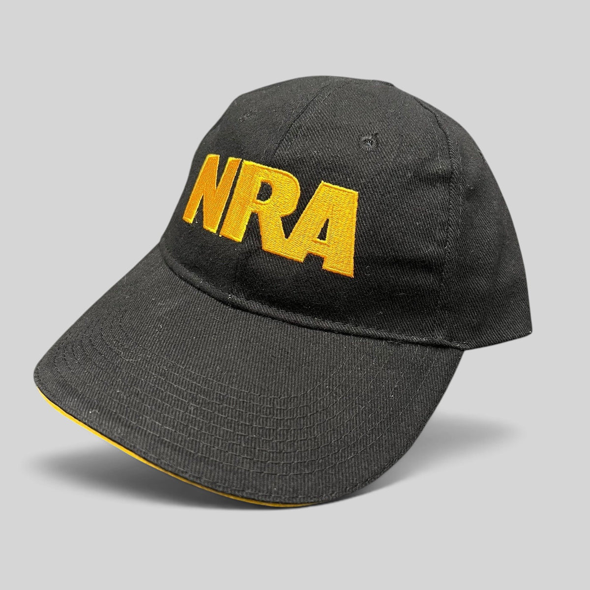 Raree Finds black strapback hat with bold yellow embroidered NRA logo on the front and a curved brim