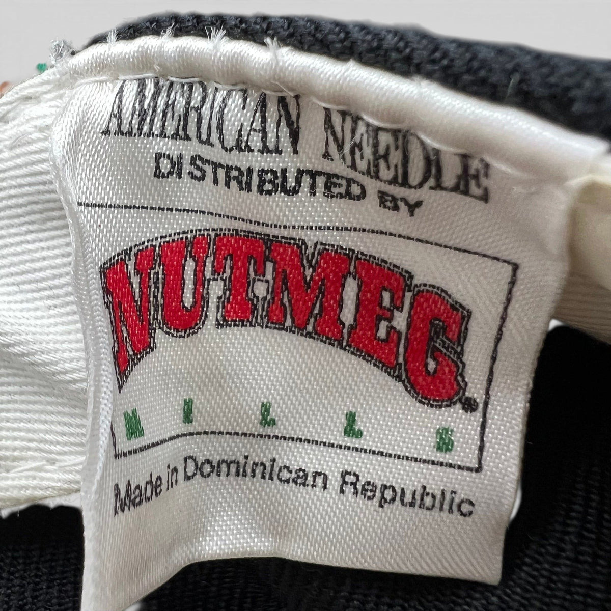 Raree Finds vintage Nutmeg Mills and American Needle clothing label tag from a 1990s Los Angeles Dodgers snapback hat.