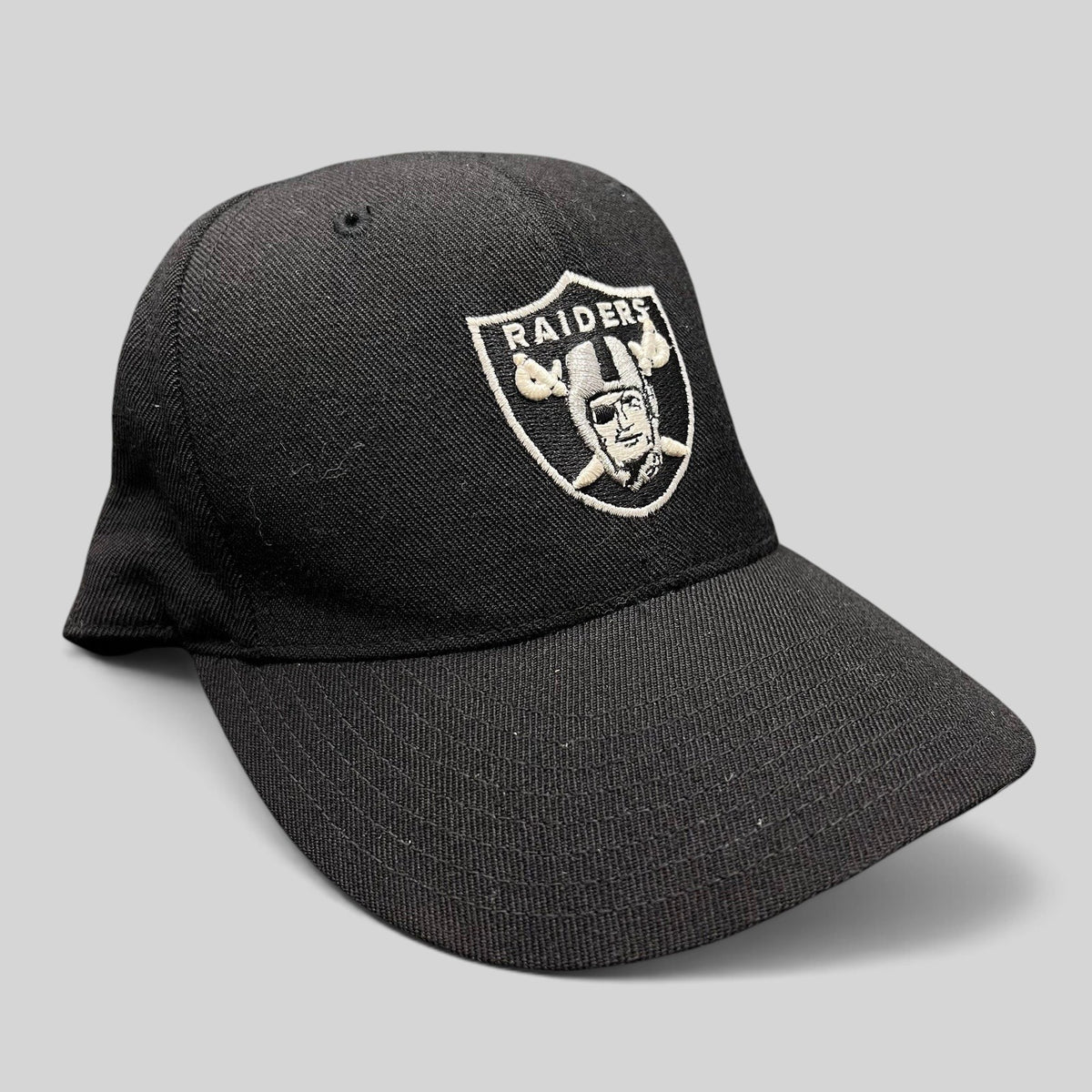 Raree Finds vintage black Oakland Raiders Reebok fitted hat with silver embroidered shield logo on wool blend fabric