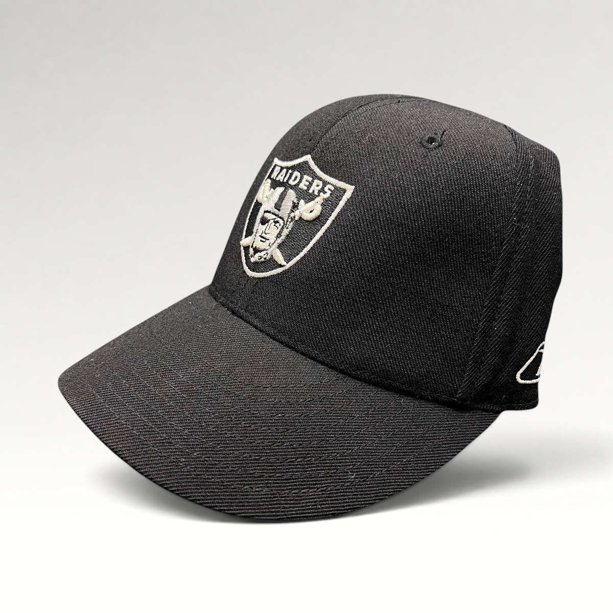 Raree Finds vintage Oakland Raiders Reebok fitted hat in black wool blend with silver embroidered shield logo