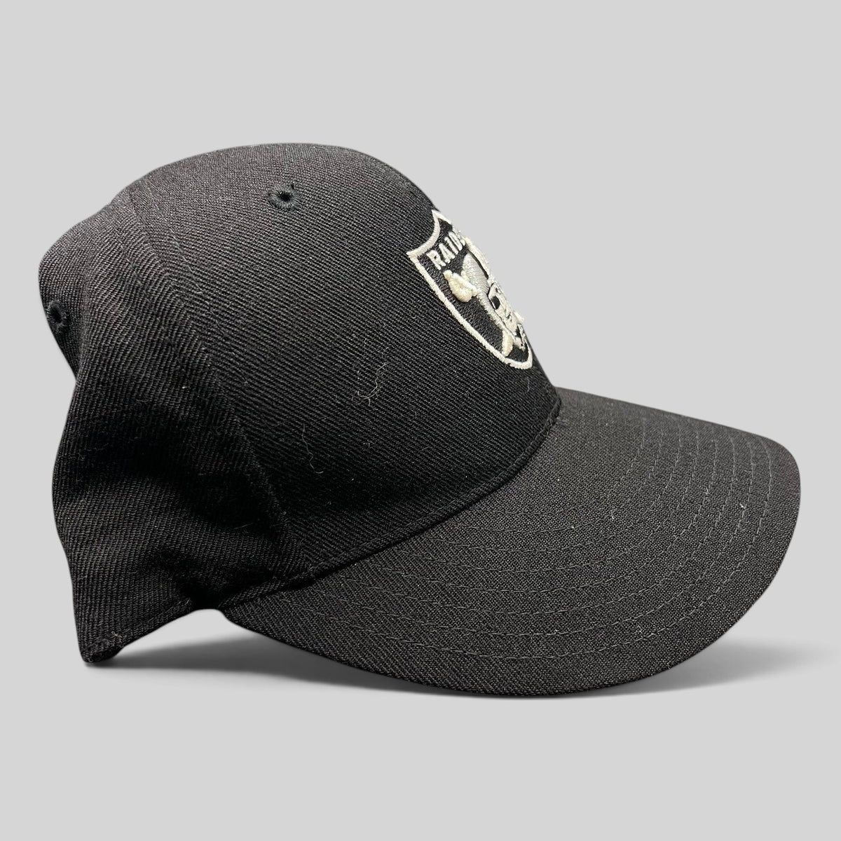 Raree Finds vintage Oakland Raiders Reebok fitted hat in black wool blend with silver embroidered shield logo