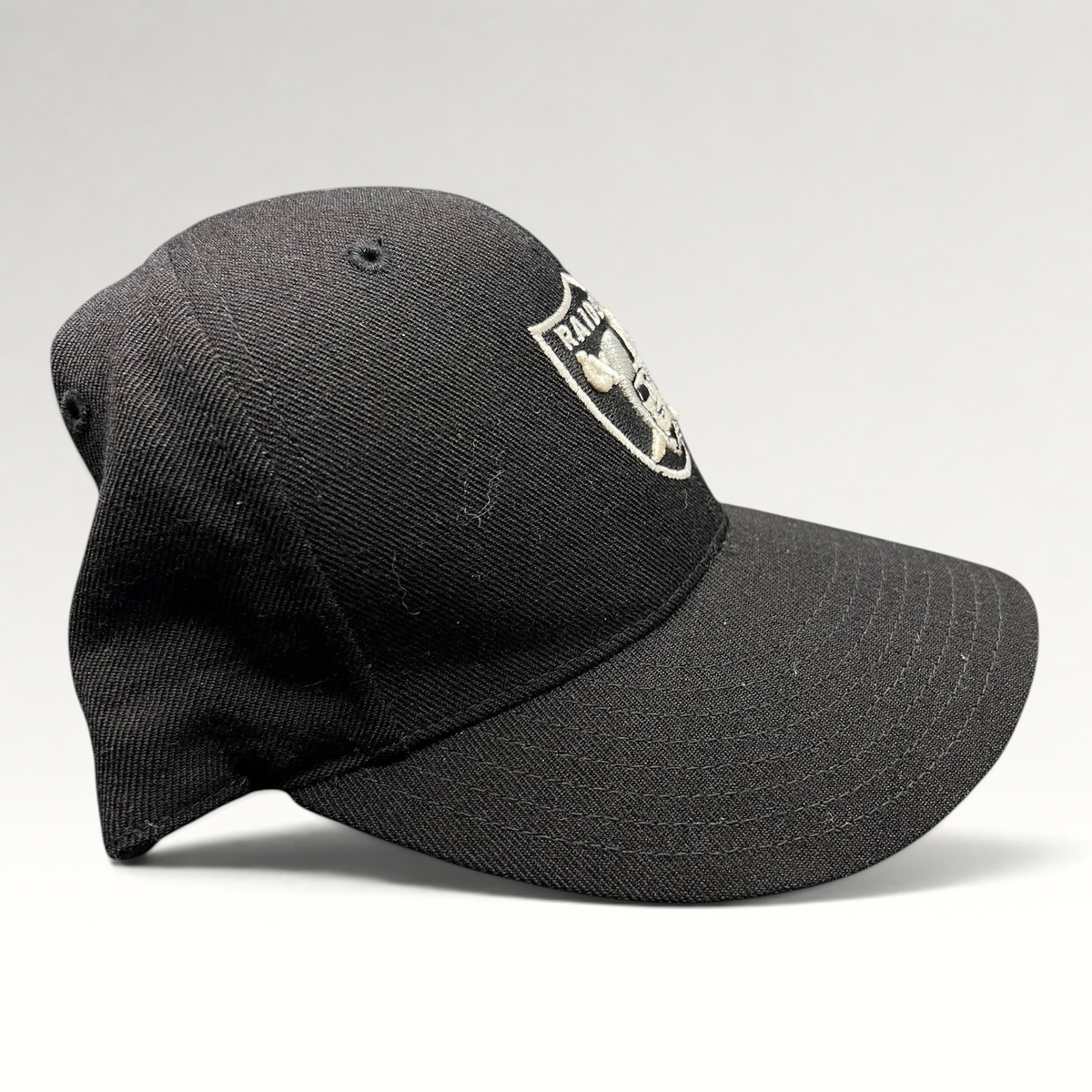 Raree Finds vintage Oakland Raiders Reebok fitted hat in black wool blend with silver embroidered shield logo