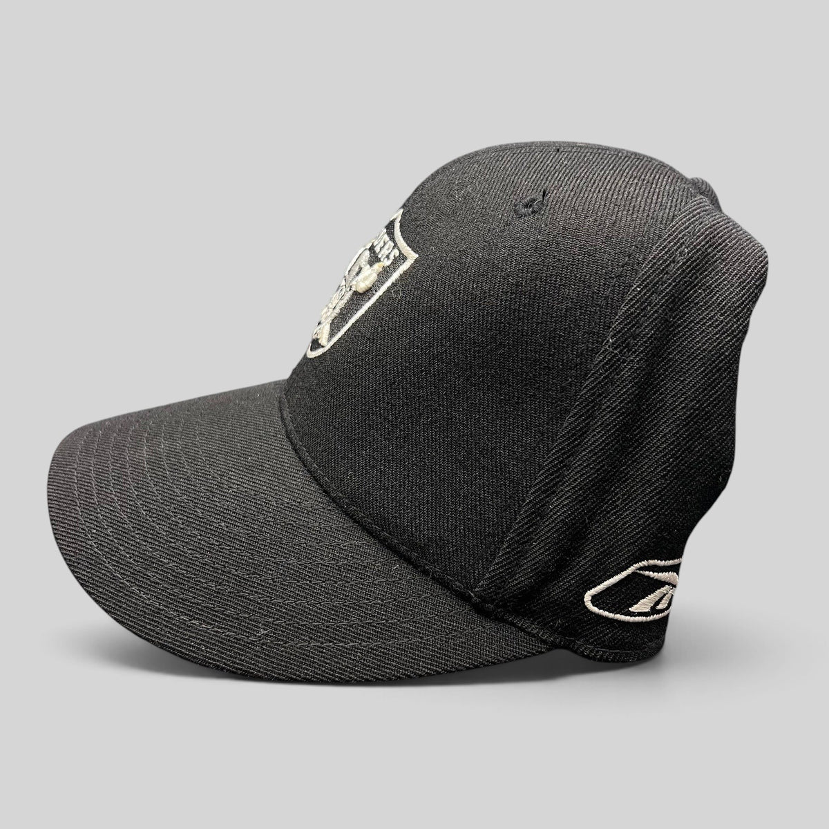 Raree Finds vintage Reebok Oakland Raiders black wool blend fitted hat with silver shield logo and side embroidery