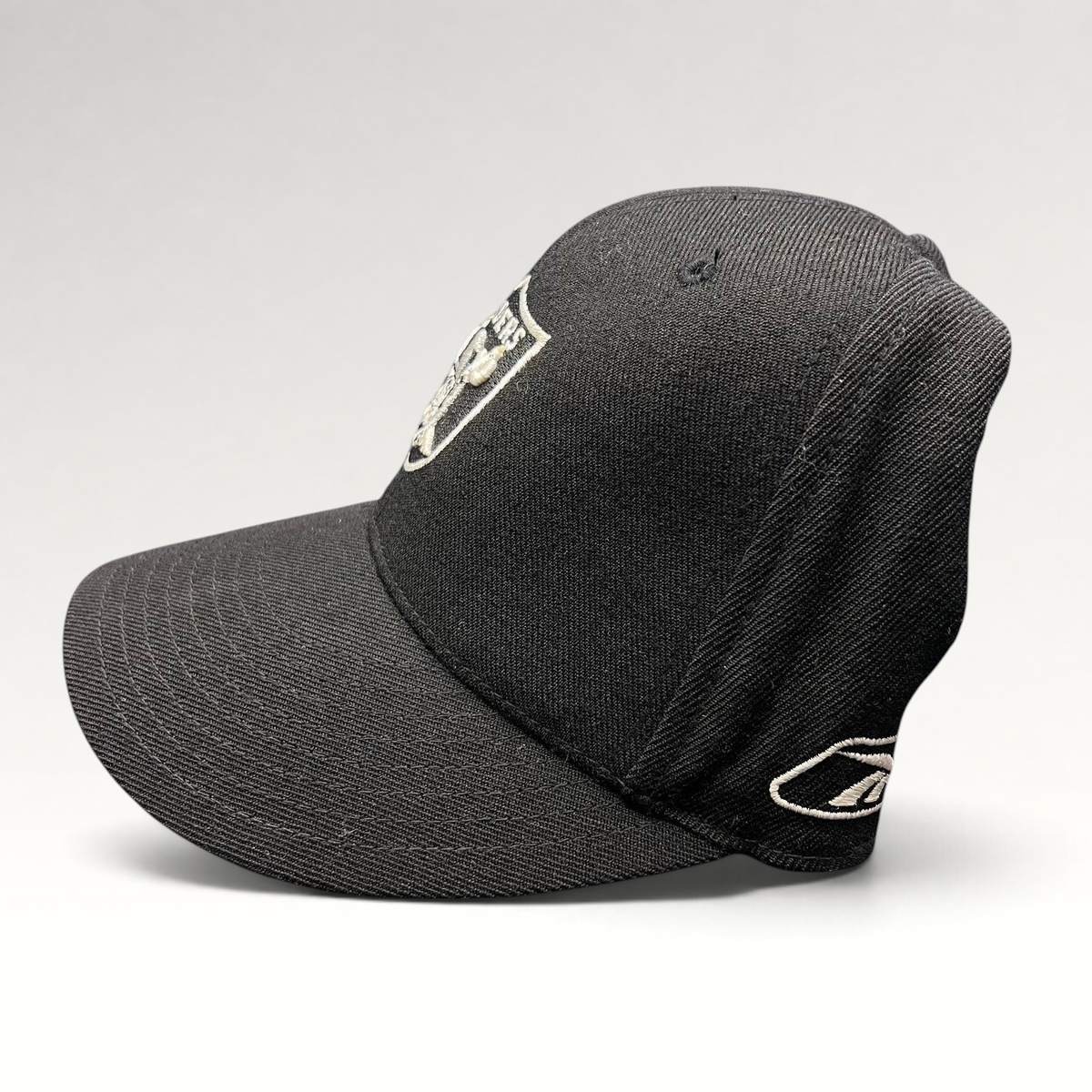 Raree Finds vintage Reebok Oakland Raiders black wool blend fitted hat with silver shield logo and side embroidery