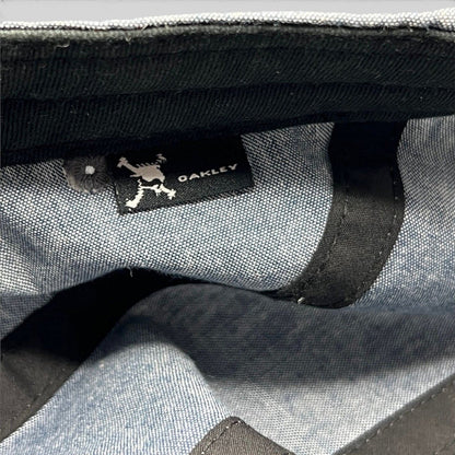 Raree Finds Oakley 5-panel cap interior showing the skull logo brand tag on light denim chambray fabric