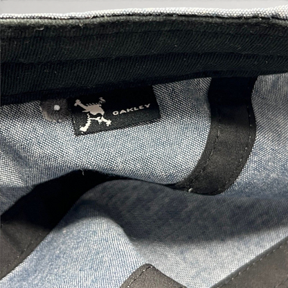 Raree Finds Oakley 5-panel cap interior showing the skull logo brand tag on light denim chambray fabric