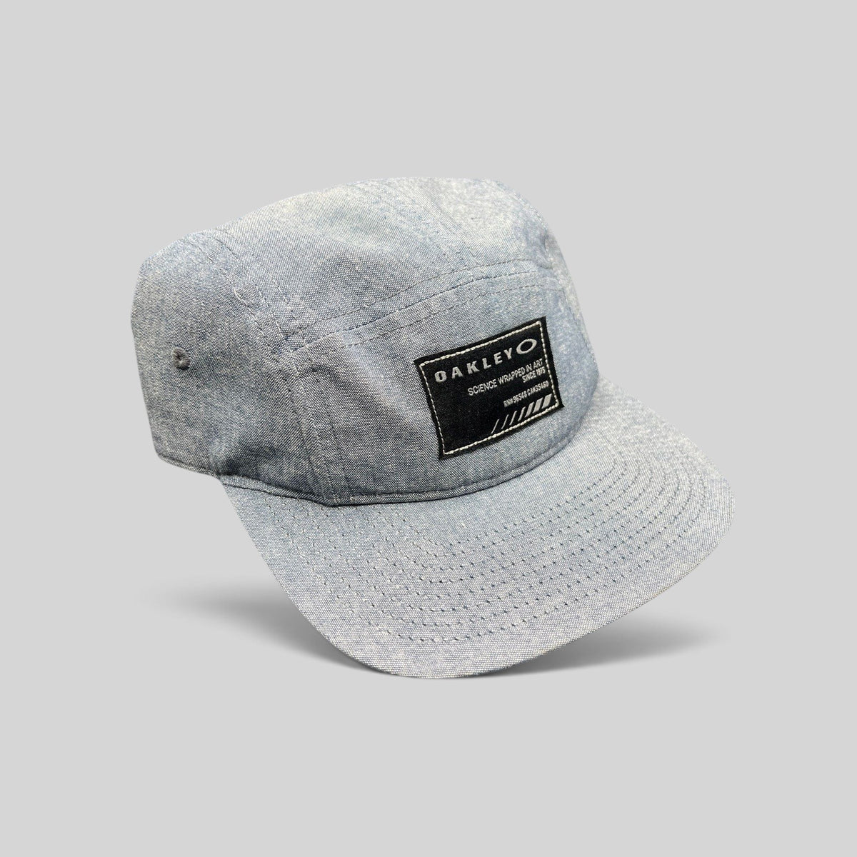 Raree Finds Oakley light denim chambray 5-panel camp cap with black Science Wrapped in Art patch and metal buckle