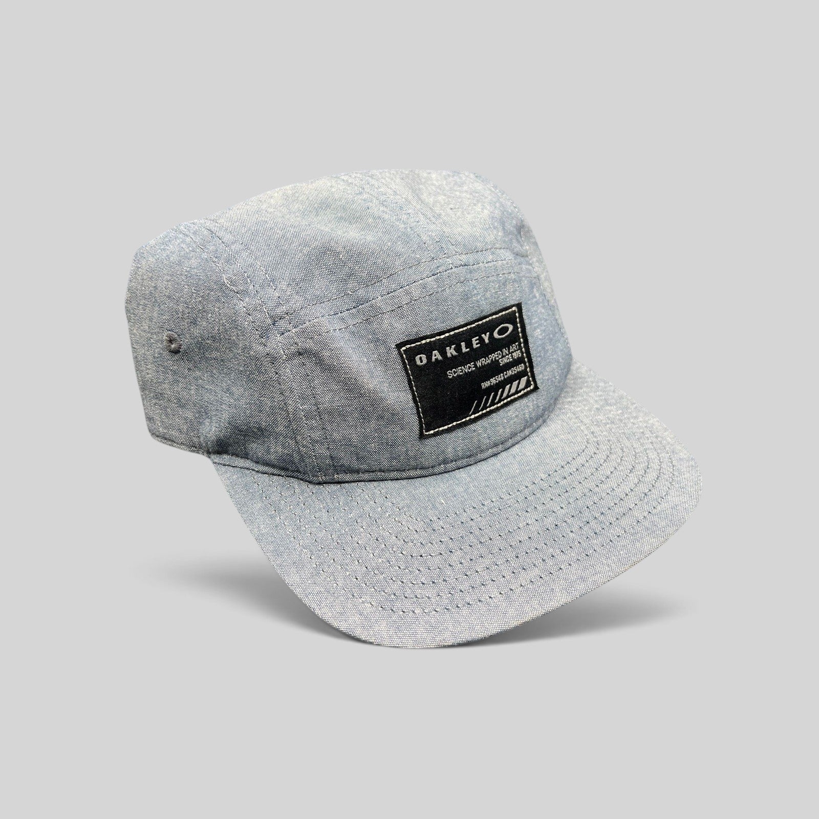 Raree Finds Oakley light denim chambray 5-panel camp cap with black Science Wrapped in Art patch and metal buckle