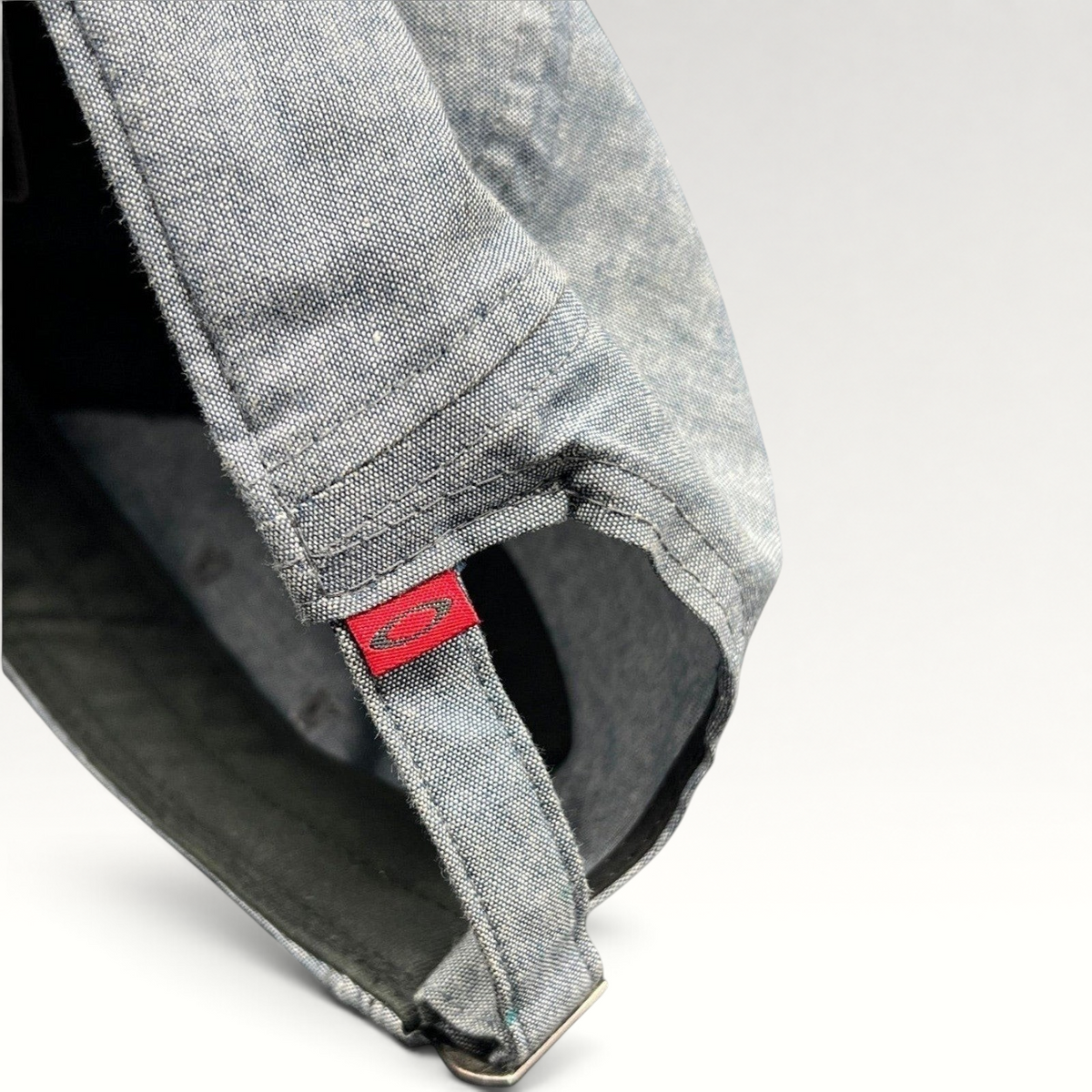 Raree Finds Oakley 5-panel cap in light denim chambray with red skull logo tag on the adjustable metal buckle strap