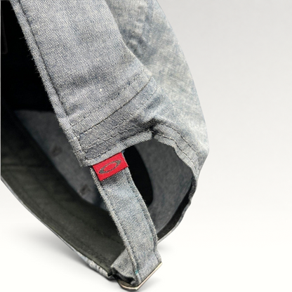 Raree Finds Oakley 5-panel cap in light denim chambray with red skull logo tag on the adjustable metal buckle strap