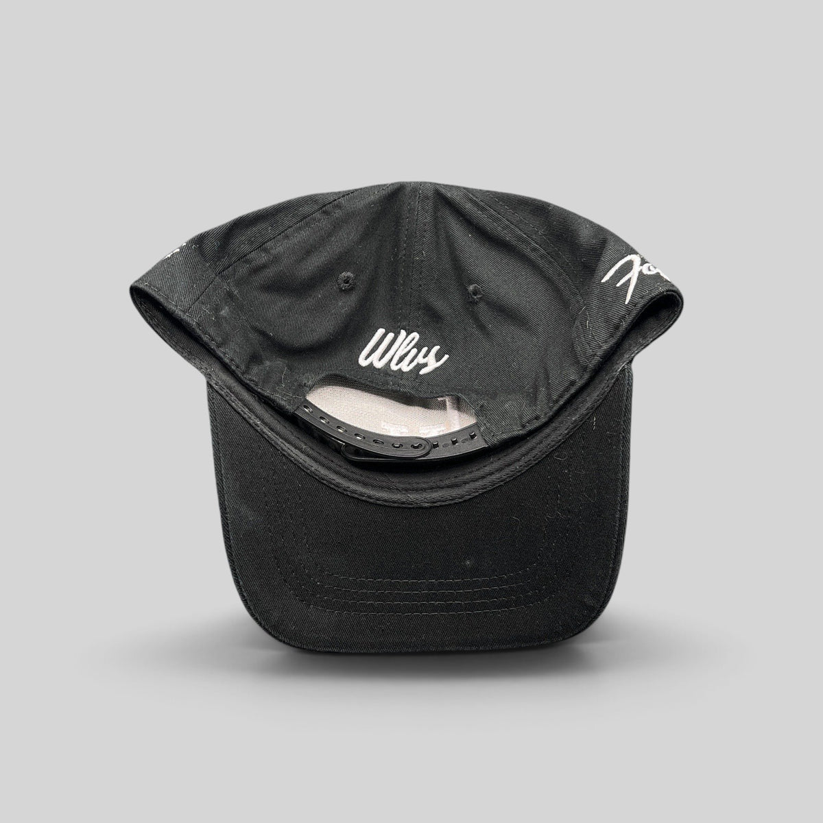 Raree Finds black Okami Brand strapback hat with white Wlvs script embroidery on the back and adjustable strap closure
