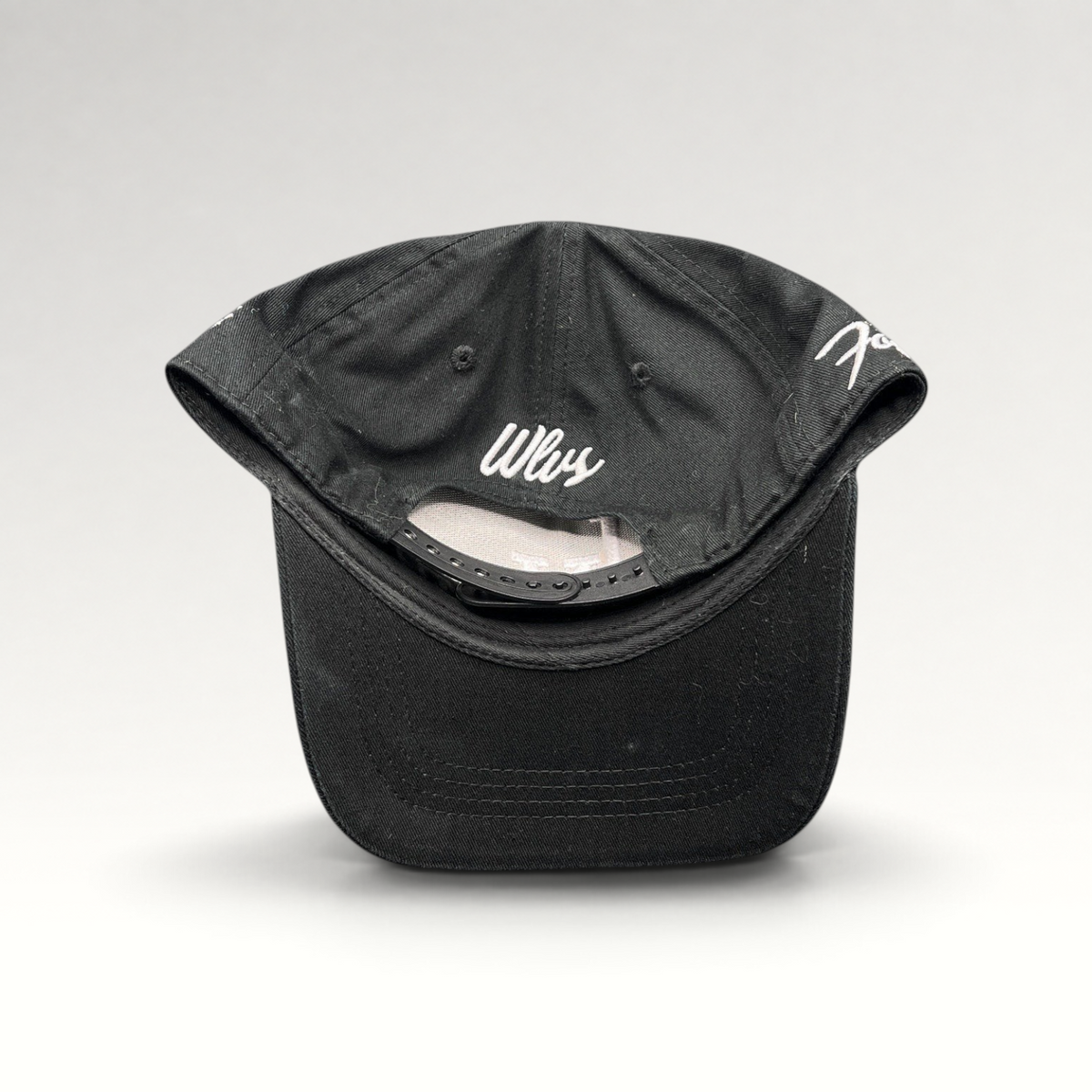 Raree Finds black Okami Brand strapback hat with white Wlvs script embroidery on the back and adjustable strap closure