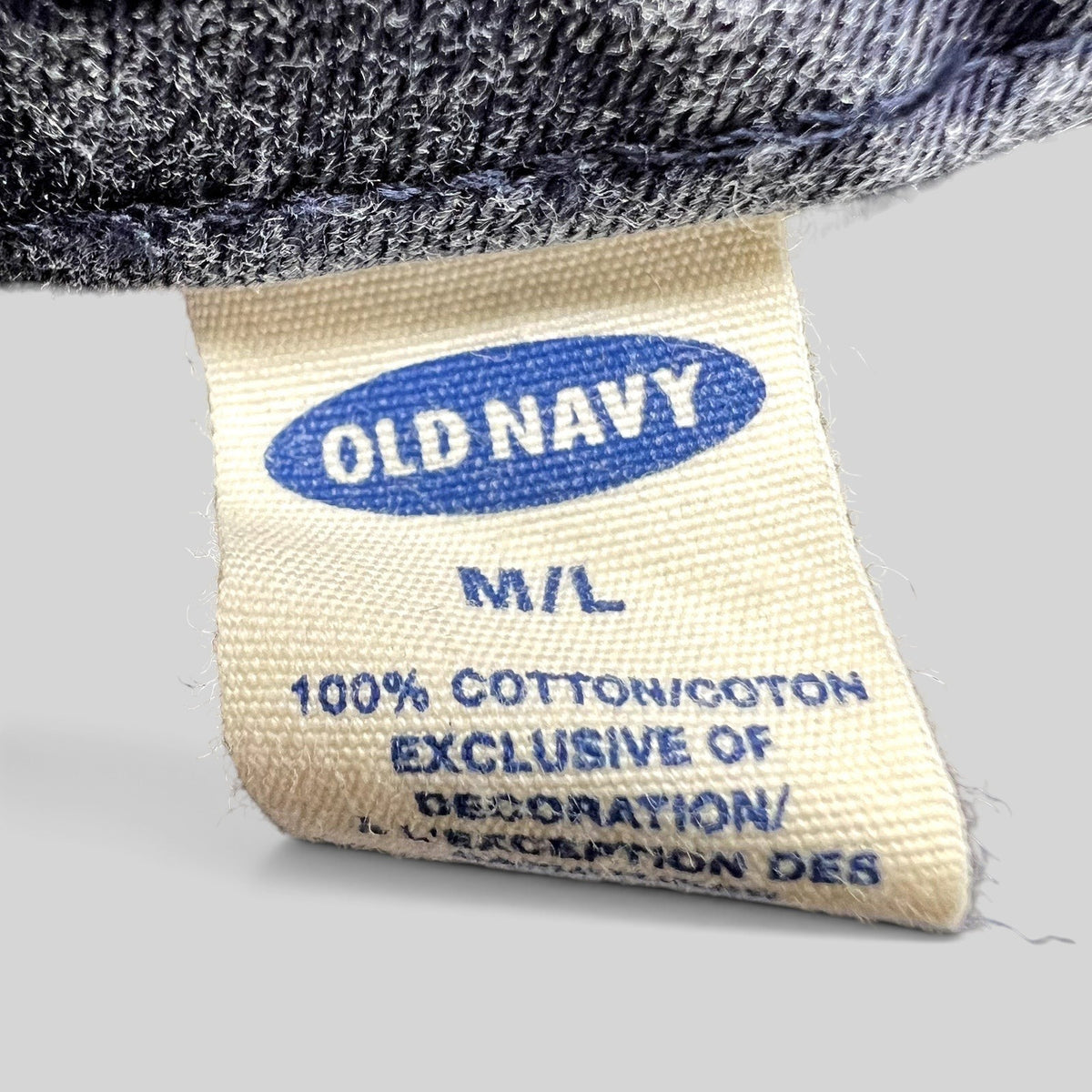 Raree Finds vintage Old Navy hat care label showing 100% cotton material and M/L size on a washed navy fabric