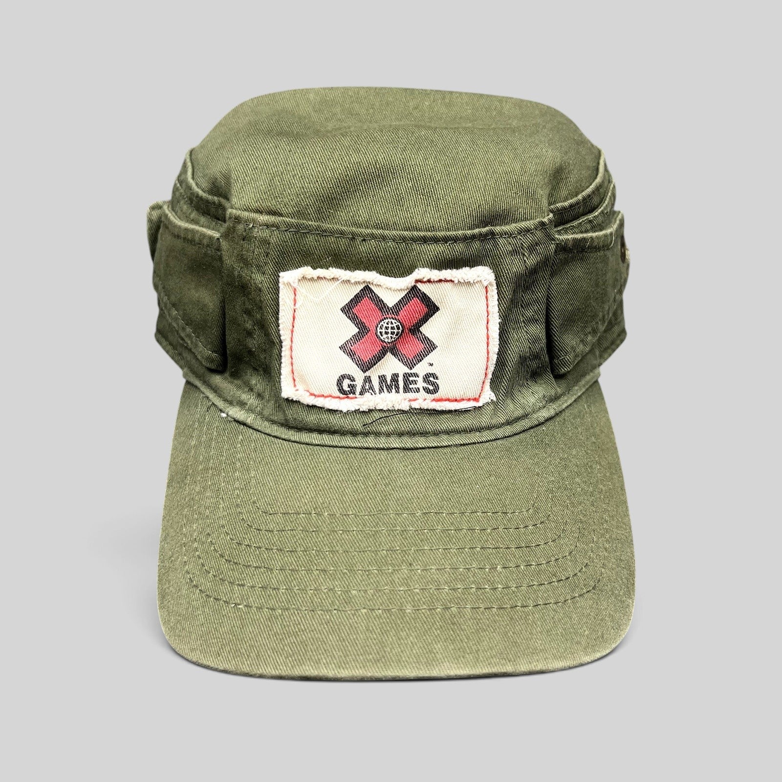 Raree Finds vintage olive green cotton cadet military cap with a distressed X Games patch on the front