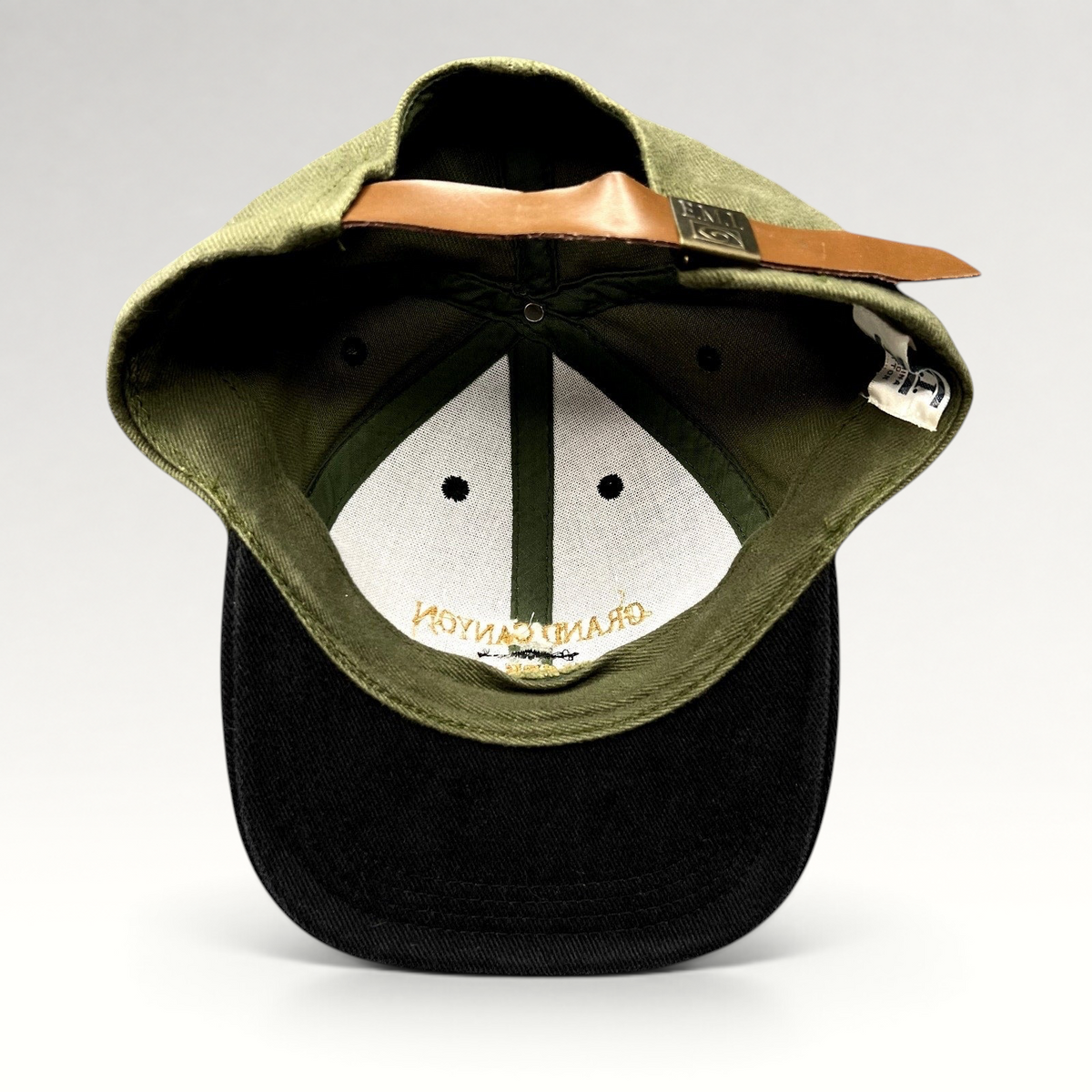 Raree Finds vintage Grand Canyon Squire Inn strapback hat in olive green and black cotton with a leather strap closure