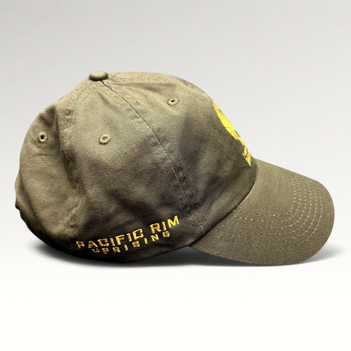 Raree Finds olive drab cotton strapback hat with gold Pacific Rim Uprising embroidery and military-inspired design.