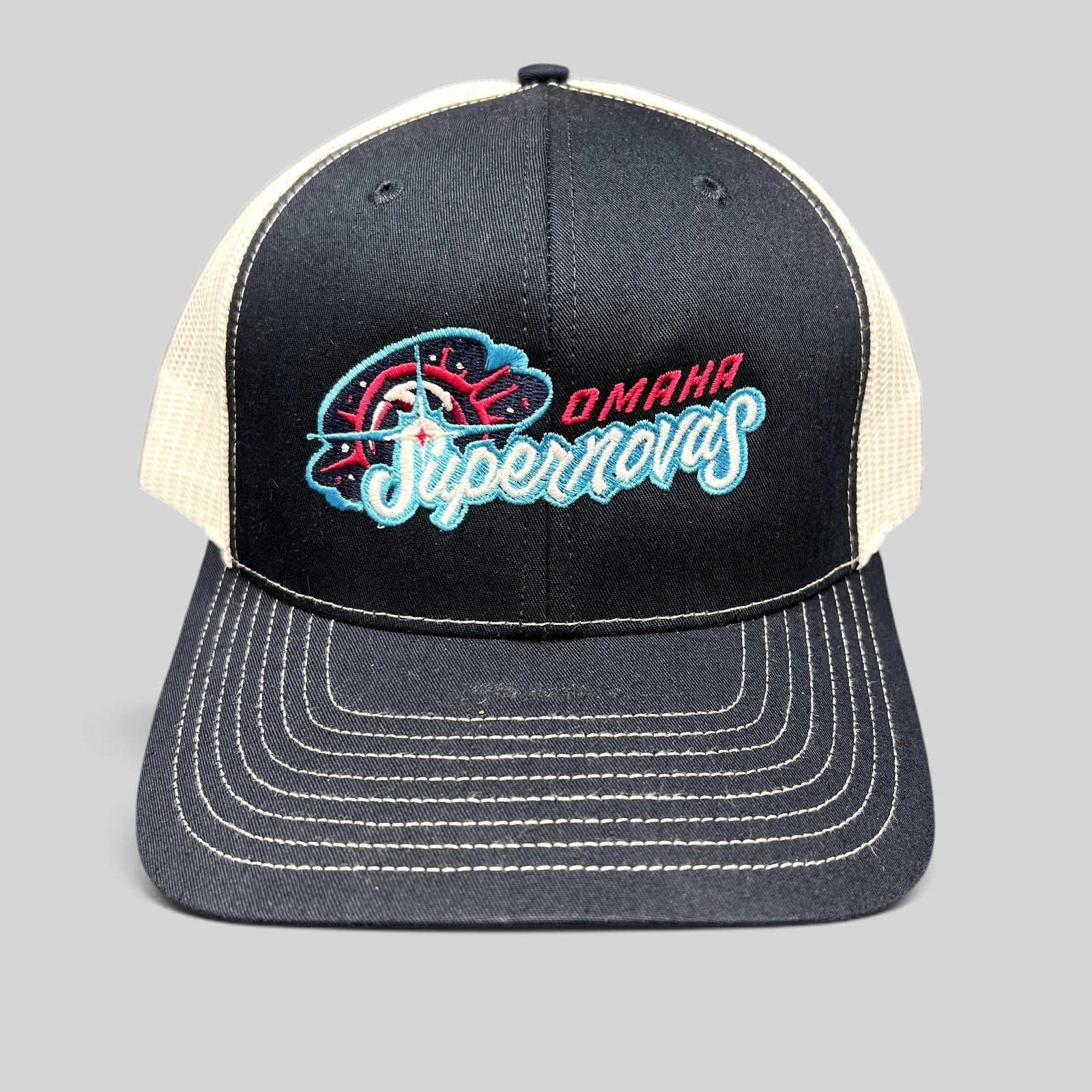 Raree Finds Omaha Supernovas Richardson 112 navy and white trucker hat with teal and pink embroidered logo