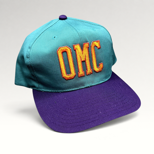 Raree Finds vintage 90s OMC snapback hat with teal crown, purple brim, and orange embroidered lettering.