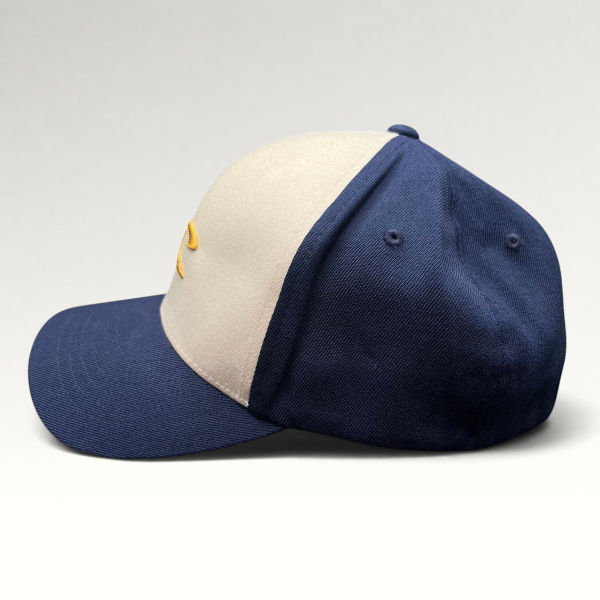 Raree Finds vintage O’Neill Flexfit surf cap with a white front panel, navy bill, and gold embroidered wave logo.