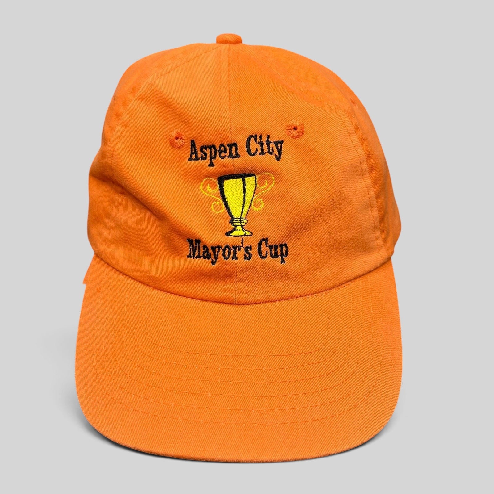 Raree Finds orange cotton dad cap featuring an embroidered Aspen City Mayor’s Cup trophy graphic and strapback closure.