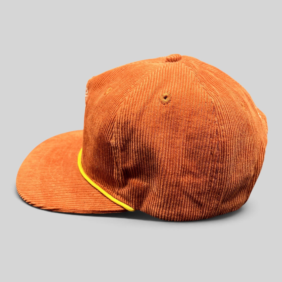 Raree Finds burnt orange corduroy snapback hat with a yellow rope accent on the brim and a structured crown.
