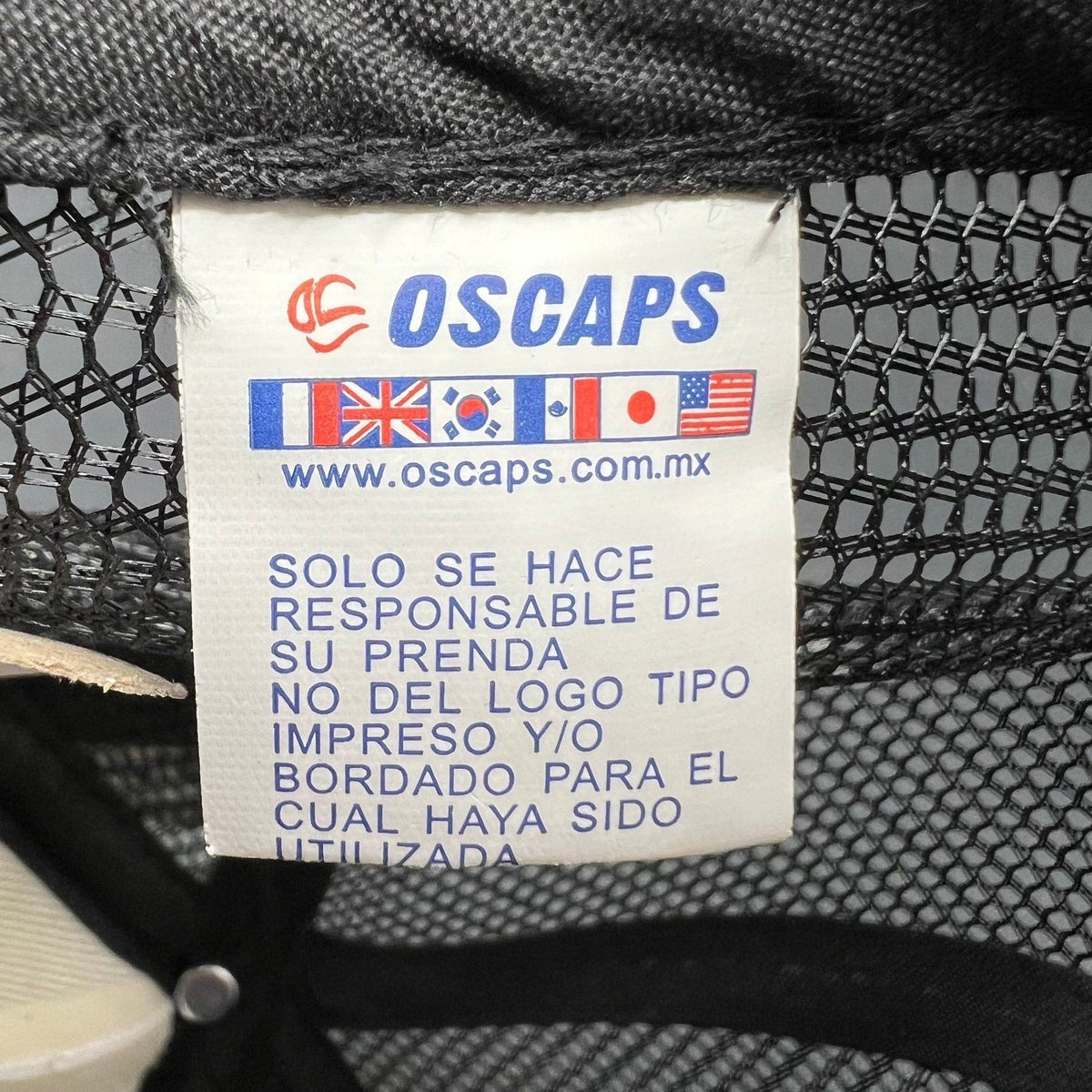Raree Finds OSCAPS brand clothing tag with international flags and website URL on a white fabric label