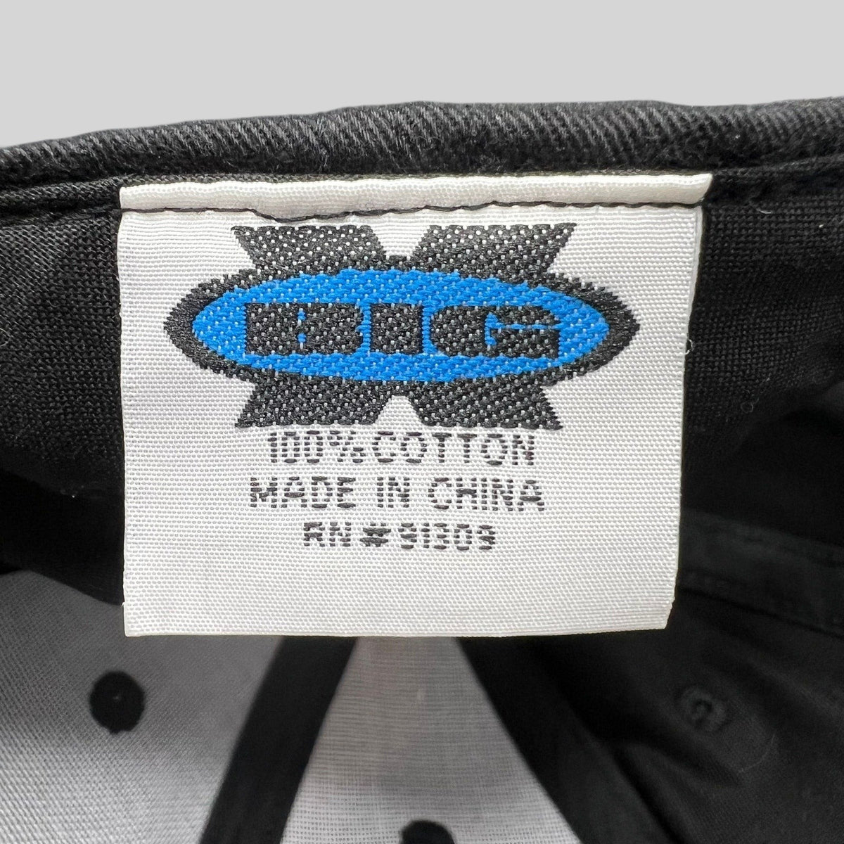 Raree Finds interior tag of The Bucket List crew hat showing 100 percent cotton material and OTC Headwear logo