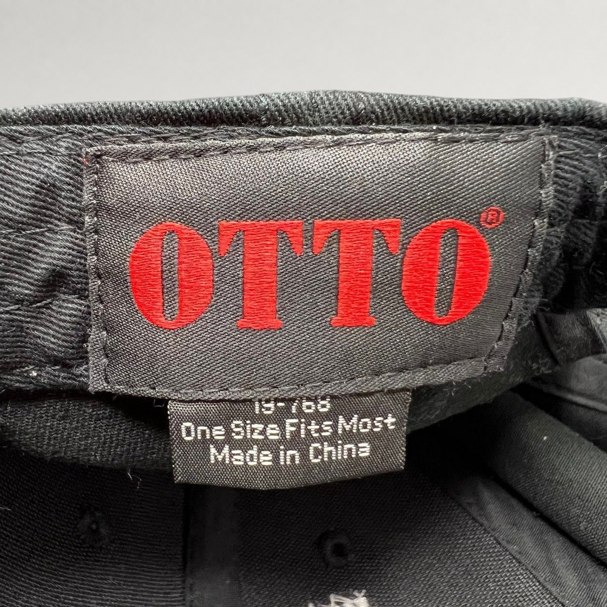 Raree Finds vintage OTTO Cap interior label with red logo text and size information on a black cotton snapback hat