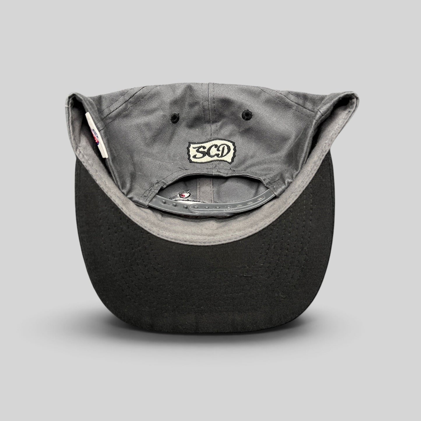 Raree Finds vintage Otto Cap snapback showing the SCD embroidered patch on the gray cotton twill back panel