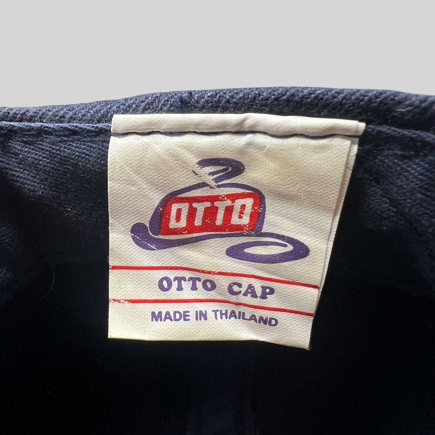 Raree Finds vintage OTTO Cap interior tag with logo and Made in Thailand text on a navy snapback hat