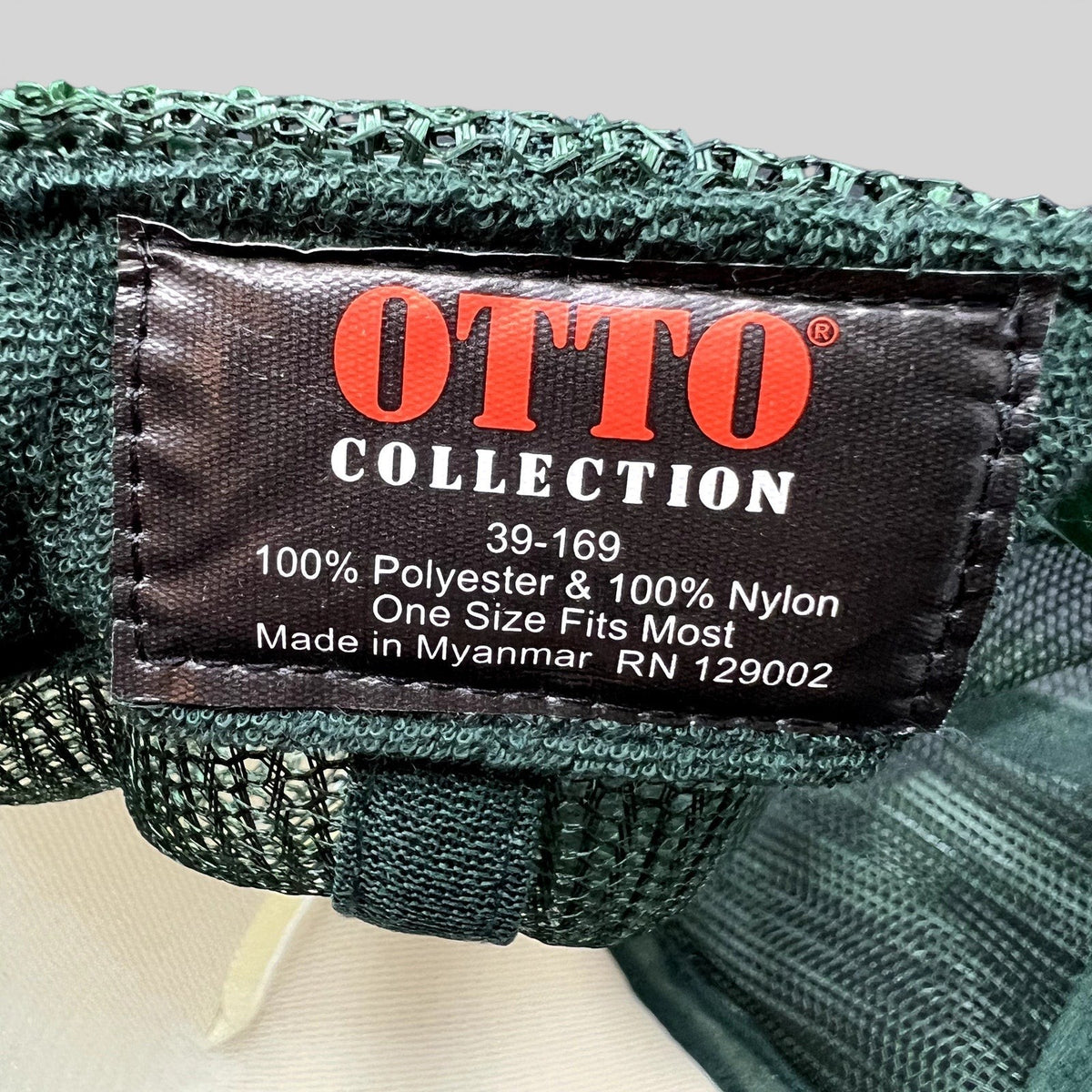 Raree Finds OTTO Collection trucker hat interior tag showing polyester and nylon material details