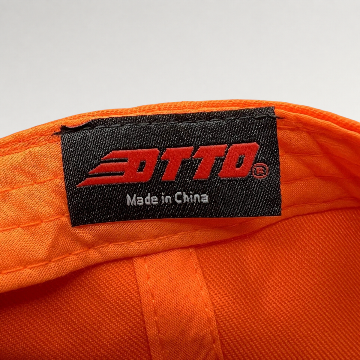 Raree Finds Otto brand label inside a blaze orange snapback hat showing Made in China text