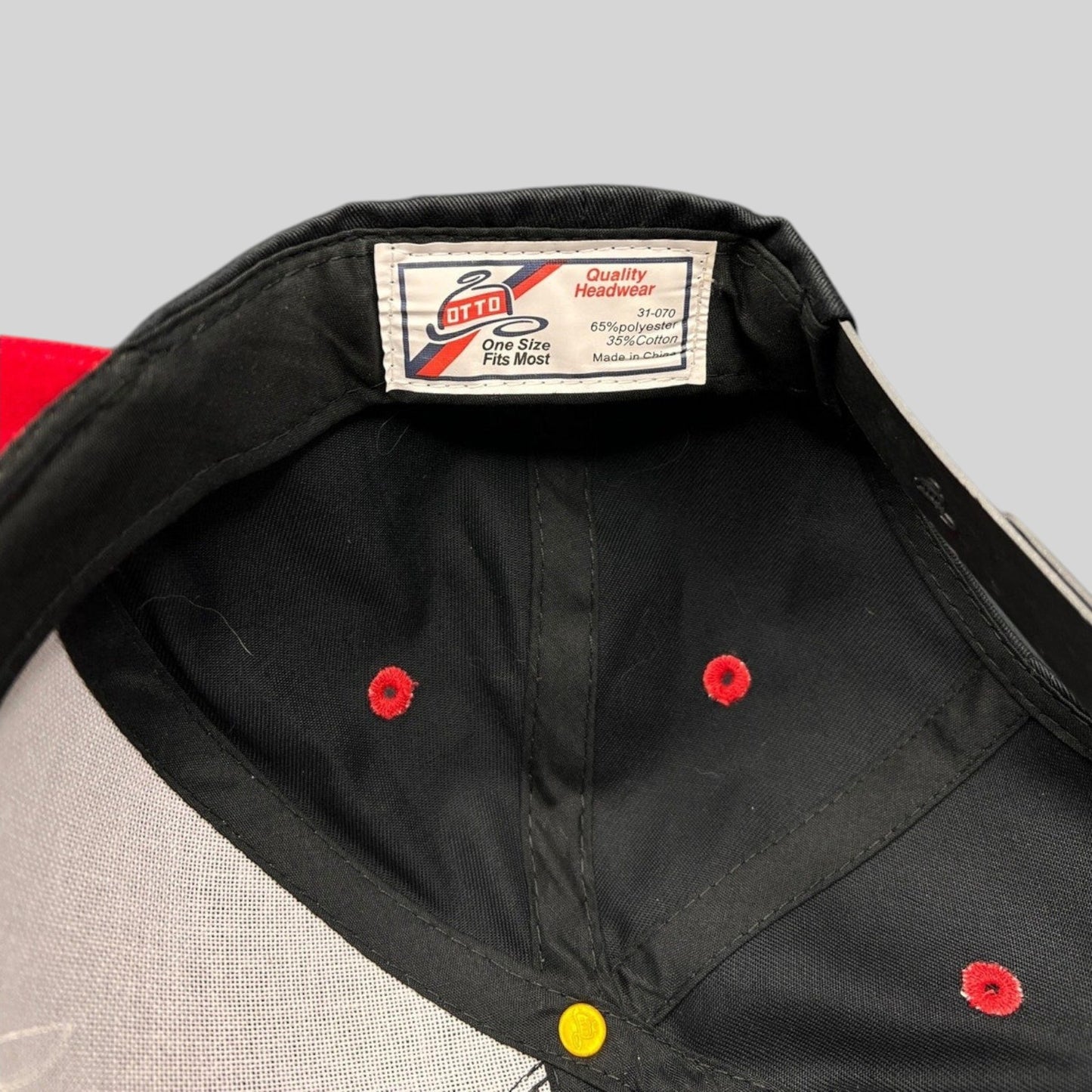 Raree Finds Otto snapback hat interior showing the brand label and red ventilation eyelets on a black crown