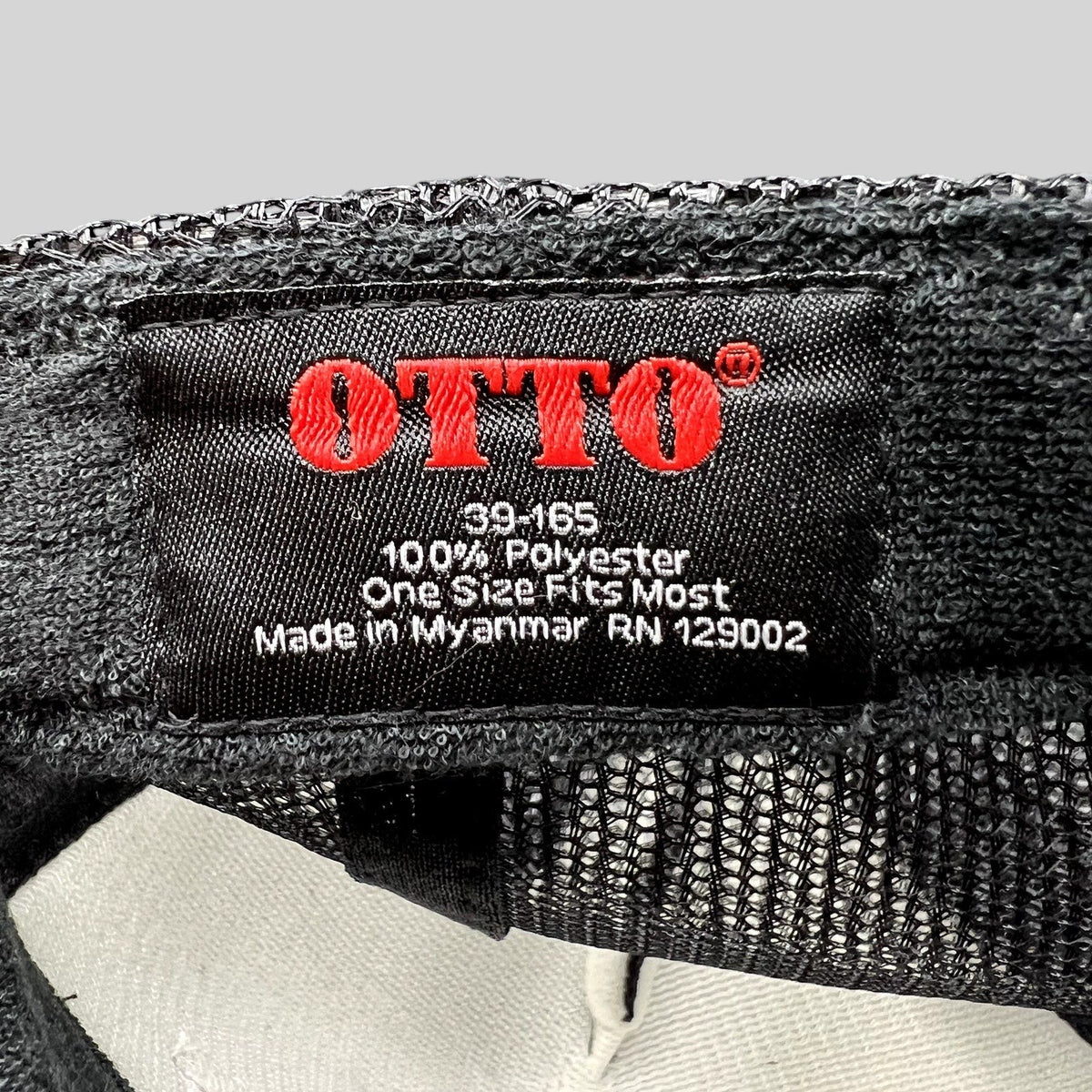 Raree Finds OTTO brand black mesh trucker hat interior label showing polyester material and one size fit details