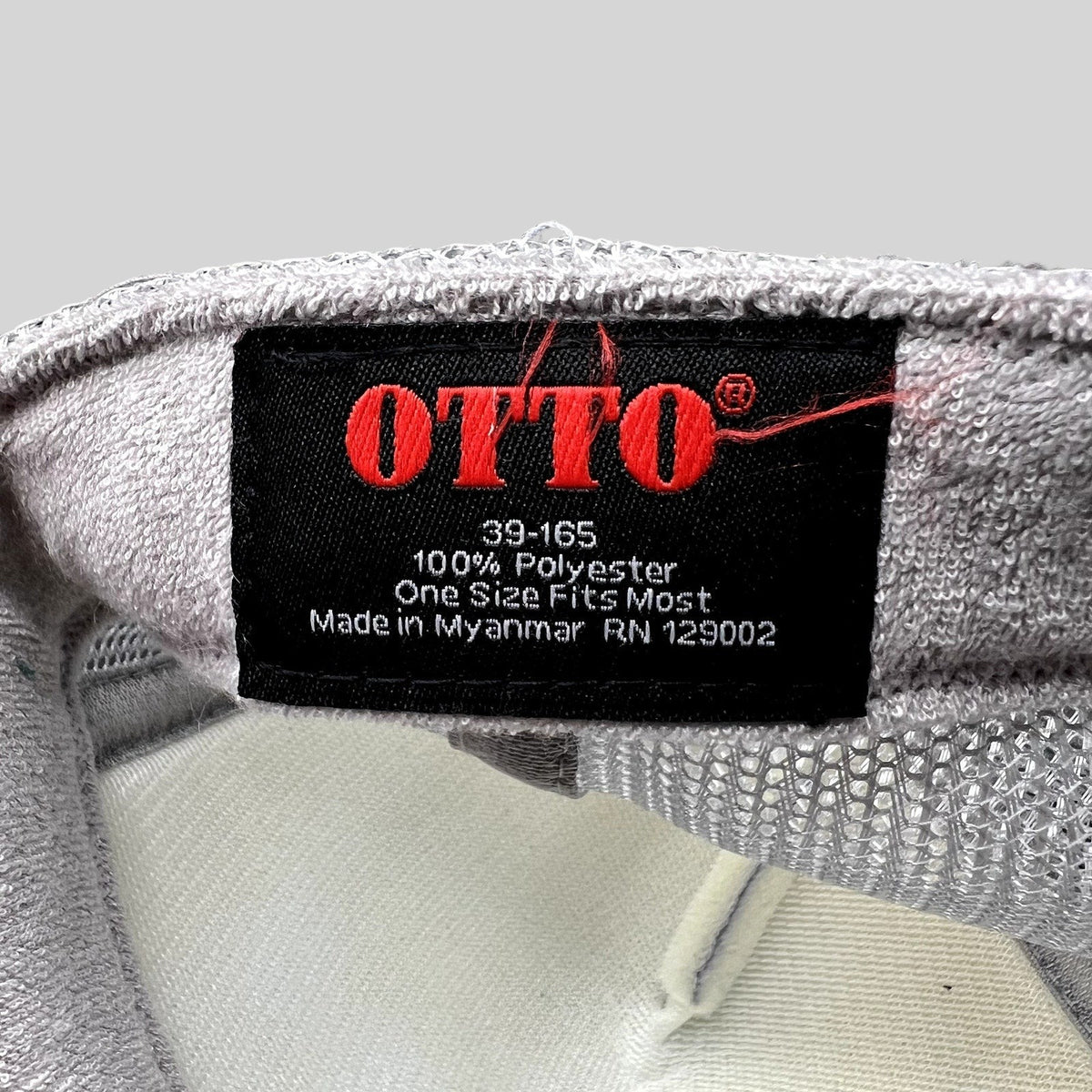 Raree Finds OTTO trucker hat interior label showing 100 percent polyester material and one size fits most details