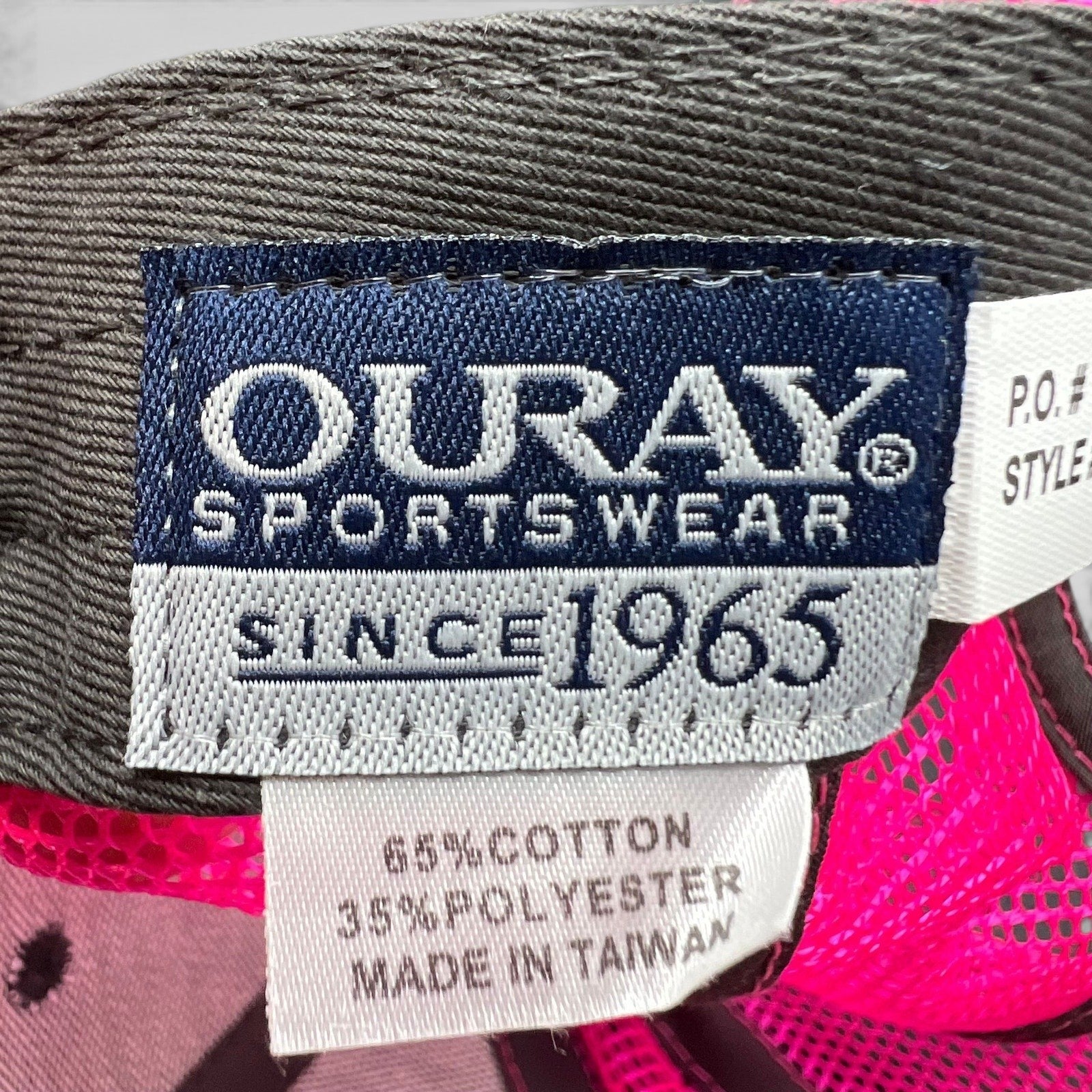 Raree Finds vintage Ouray Sportswear tag showing material composition and manufacturing details on a 90s snapback hat.