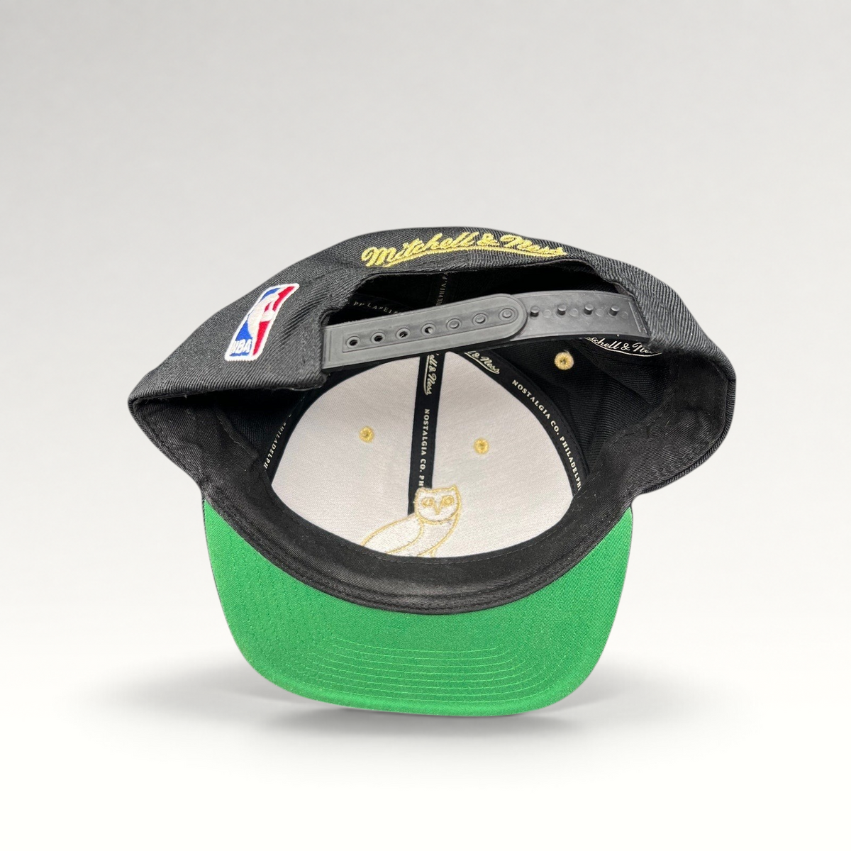 Raree Finds Mitchell & Ness x OVO Toronto Raptors snapback showing the green underbrim, interior owl logo, and NBA patch