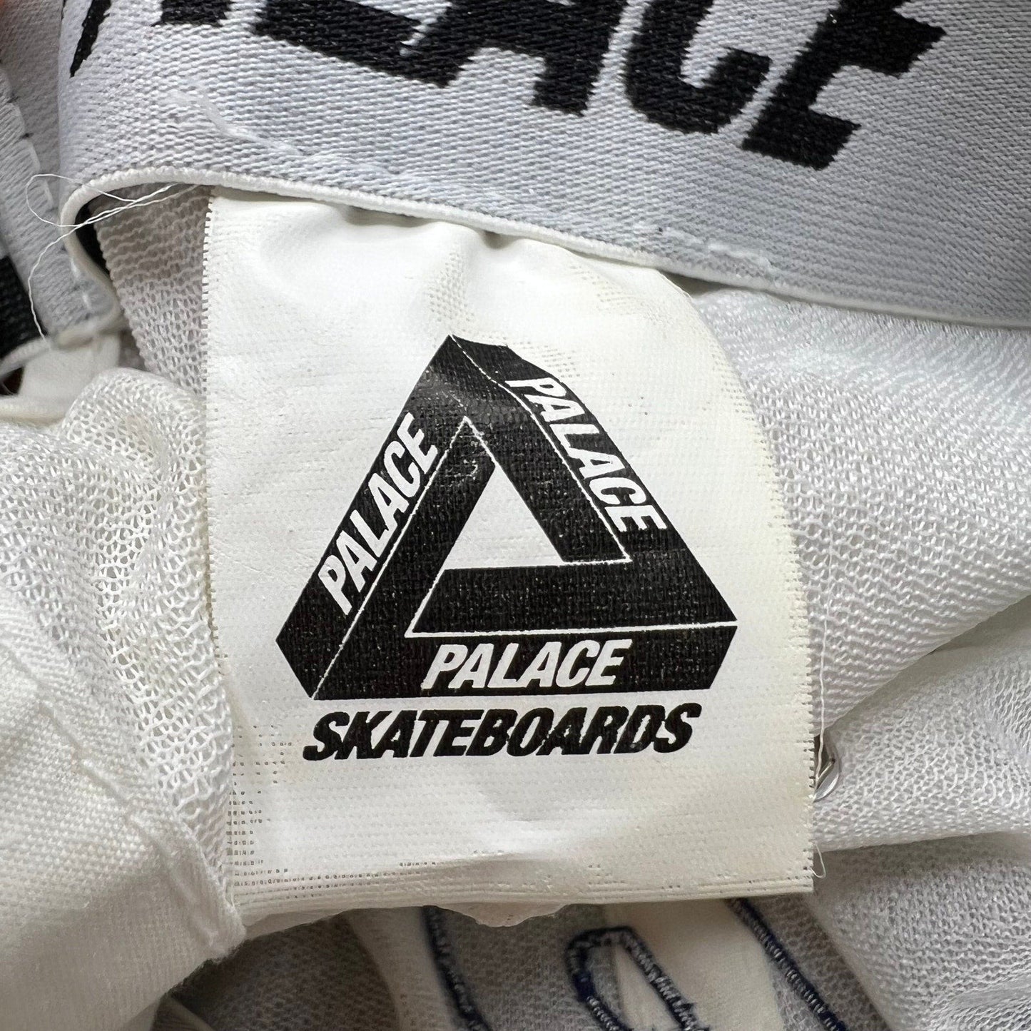 Raree Finds Palace Skateboards white hat interior tag with black Tri-Ferg logo and branding on synthetic fabric