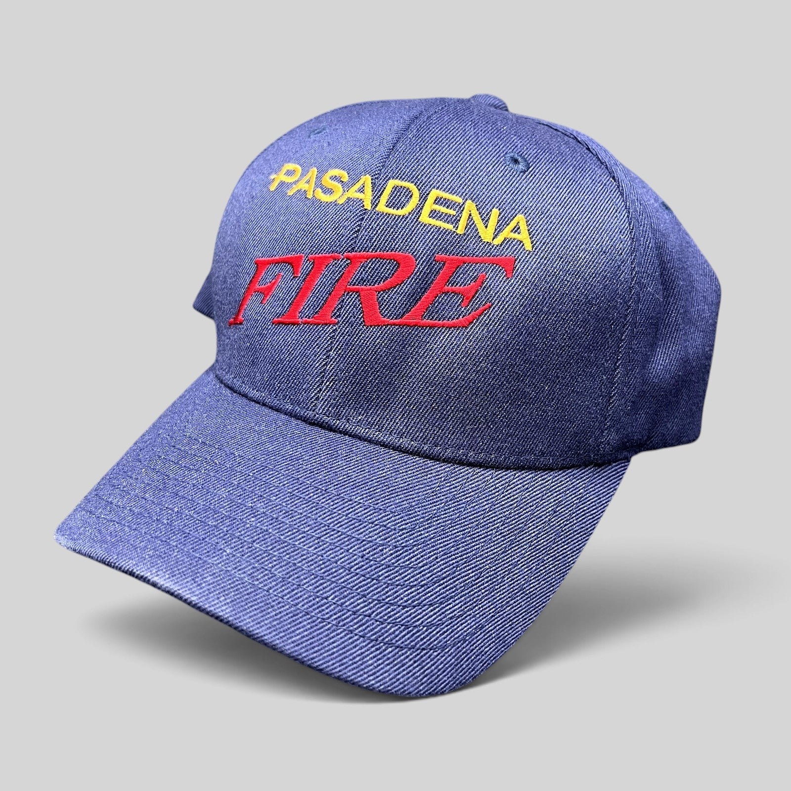 Raree Finds navy blue Yupoong Flexfit hat with embroidered Pasadena Fire lettering in red and yellow on the crown.