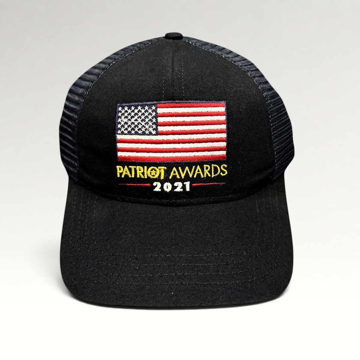 Raree Finds navy and black Patriot Awards 2021 trucker hat with an embroidered American flag and snapback closure.
