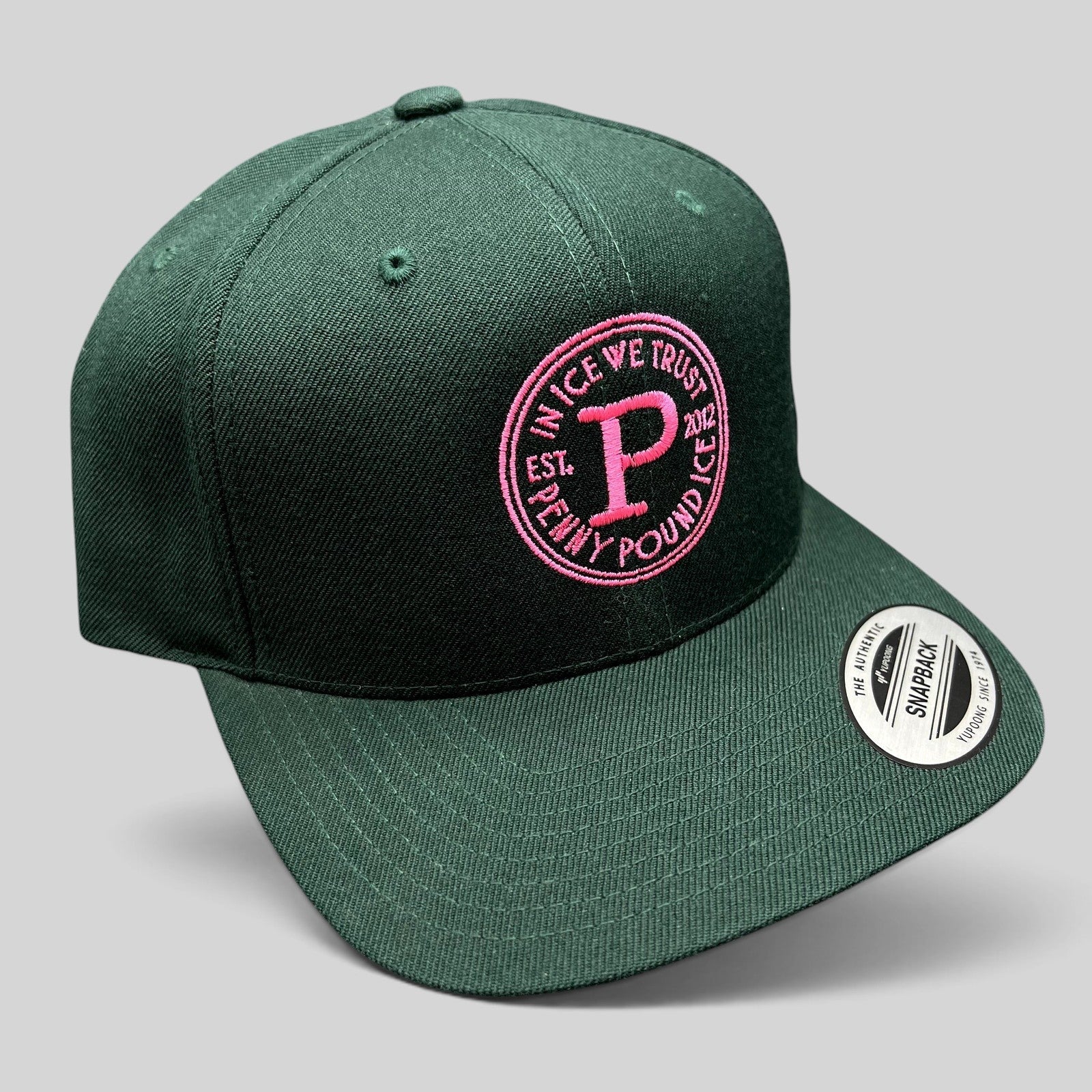Raree Finds Penny Pound Ice dark green snapback hat with pink In Ice We Trust circular logo embroidery