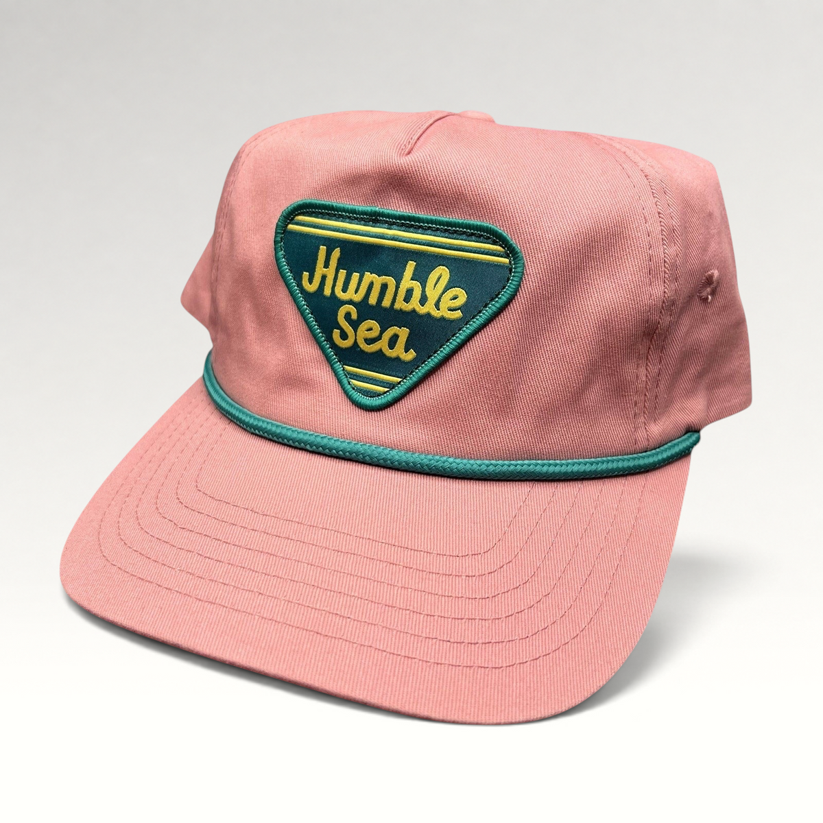 Raree Finds pink cotton strapback hat with a teal and yellow Humble Sea Brewing patch and teal rope brim detail.
