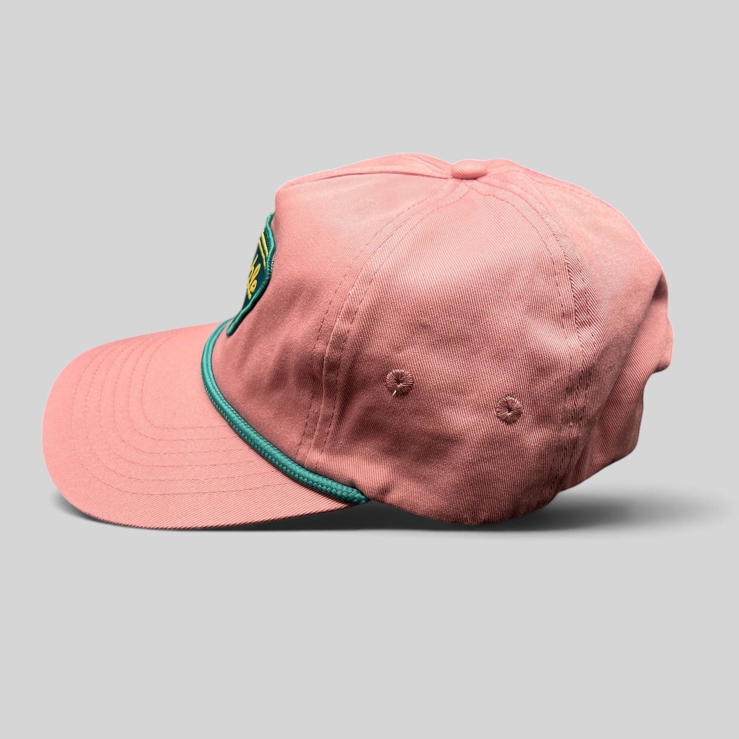 Raree Finds pink strapback hat with teal rope detail and Humble Sea Brewing patch, side profile view.