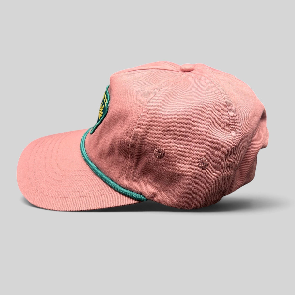 Raree Finds pink strapback hat with teal rope detail and Humble Sea Brewing patch, side profile view.